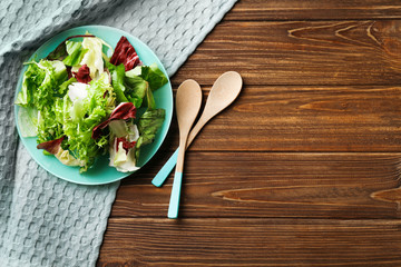 Plate with fresh salad on table