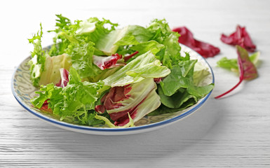 Plate with fresh salad on white wooden table