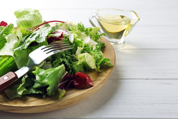 Plate with fresh salad on white wooden table, closeup