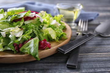 Plate of fresh salad on wooden table, closeup