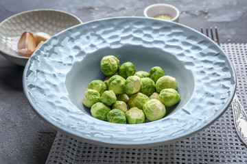 Plate with fresh Brussels sprouts on table