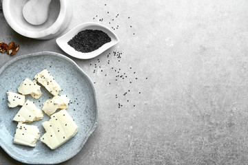 Plate with cheese on grey background