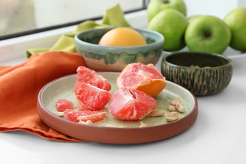 Plate with grapefruit on windowsill
