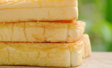 baked cheese bread slice on wooden chopblock