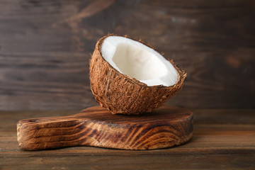Half of ripe coconut on wooden board
