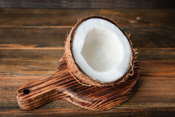 Half of ripe coconut on wooden board