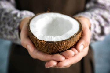 Woman holding coconut half, closeup © Africa Studio