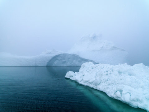 Icebergs in foggy day on Arctic Ocean in Greenland