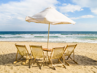 Beach chairs and umbrella on the sea coast
