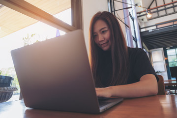 Closeup image of a beautiful Asian business woman looking , working and typing on laptop keyboard in office