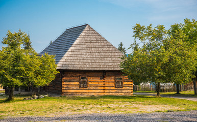 Obraz premium Old Wooden House with Trees on a Sunny Day