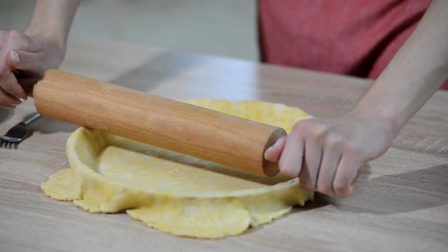 A woman making a crust for a tart. Making tart dough
