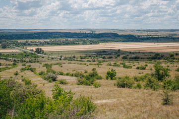 Fototapeta premium Landscape with summer steppe and cloudy sky in Donbass region of Ukraine