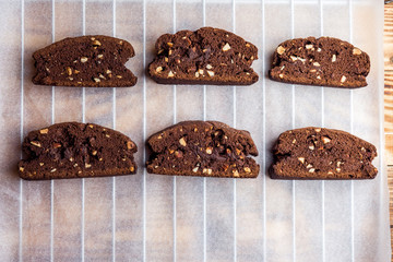 Homemade chocolate biscotti cookies with almonds on parchment paper. Top view