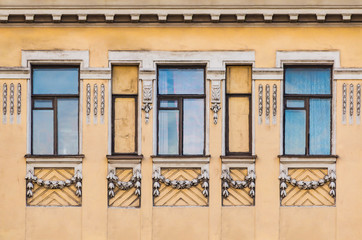 Several windows in a row on the facade of the urban historic building front view, Saint Petersburg, Russia

