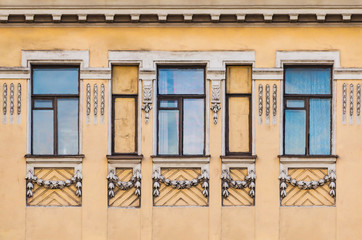 Several windows in a row on the facade of the urban historic building front view, Saint Petersburg, Russia
