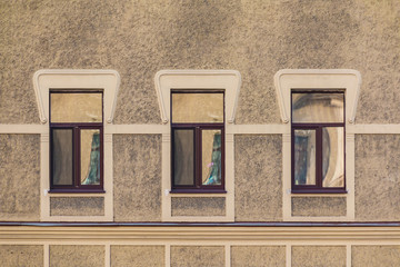 Fototapeta na wymiar Three windows in a row on the facade of the urban historic building front view, Saint Petersburg, Russia 