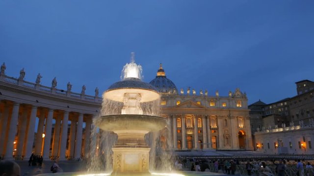 a panning shot of a fountain in saint peter's square in rome, italy