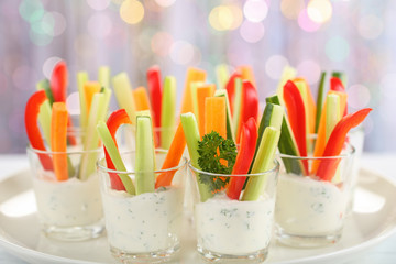 Verrines appetizer with carrot, cucumber, celery and red bell pepper sticks in glasses on platter...