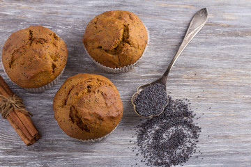 Pumpkin muffins with poppy seeds and cinnamon on a wooden table. Delicious homemade food