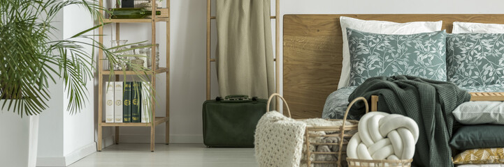 Green suitcase next to bed