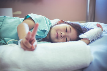 Obraz na płótnie Canvas Illness asian child admitted in hospital with saline iv drip on hand.