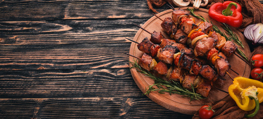 Marinated baked kebab with onions and spices. On a wooden background. Top view. Free space for text.