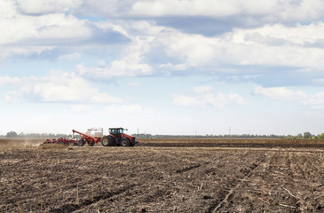 Fototapeta premium Modern tractor handles the field