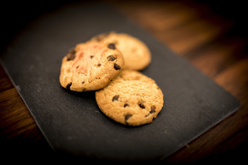 Delicious, yummy and luxurious home baked chocolate chip shortbread cookies resting on a black slate background