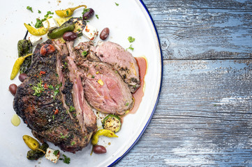 Barbecue marinated lamb roast with vegetable and feta as top view on a tray