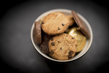 Delicious, yummy and luxurious bowl of luxury biscuits including chocolate chip shortbread cookies, chocilate digestives and orange creme biscuits