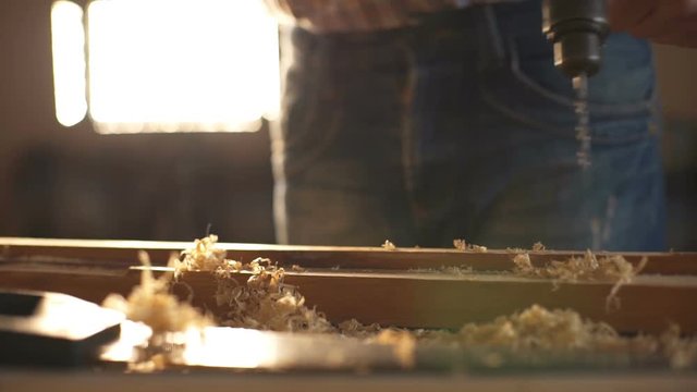 A man sawing wood Board with hand saw. Closeup. Slow motion
