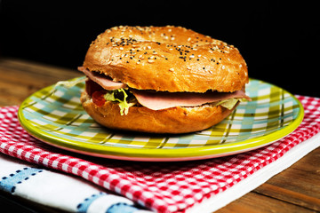 Bagel with fresh cheese and fresh lettuce on napkin