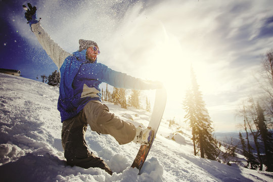 Snowboarder jumping from the springboard against the sky