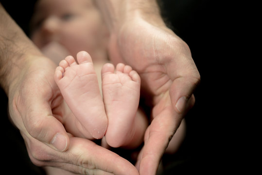 Newborn Baby feet in parents' hands -  happy family moments of parents with their children