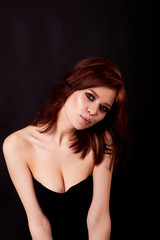 Fototapeta na wymiar Girl in Studio on dark background. Red hair, great figure. Cute face with a smile.