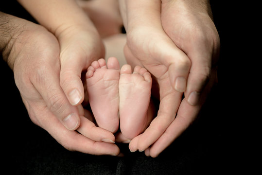 Newborn Baby feet in parents' hands -  happy family moments of parents with their children