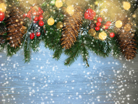 christmas decoration cones and garland lights on wooden background