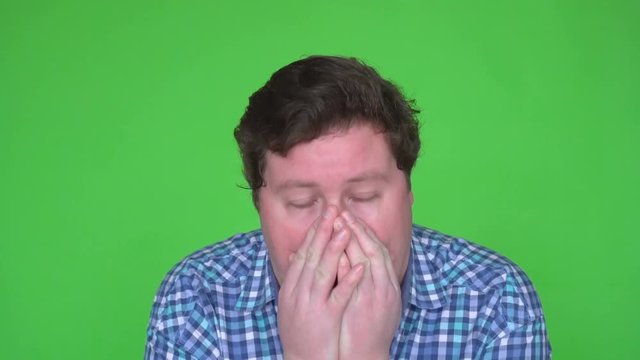 Close up Shot of a Sick Man in Plaid Shirt Caughing and Sneezing. Background is Green Screen.