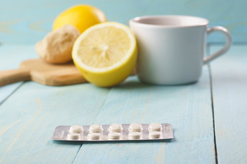 Drug for cold, tea with lemon and ginger in the background