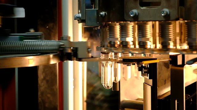 PET bottle preforms. The operation of PET bottle or plastic bottle blowing machine with lighting effect.
