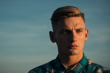 Guy with healthy skin face, blond hair on blue sky