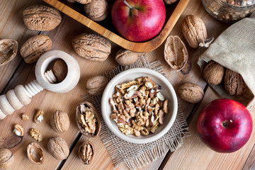 Shelled and unshelled walnuts on a wooden table, top view