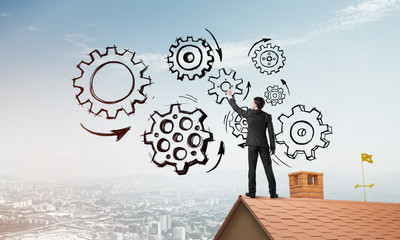 Mister boss on brick roof standing with back and draw teamwork concept. Mixed media