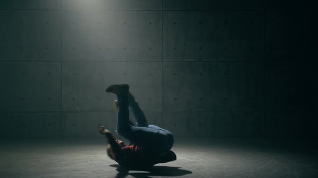 Young male breakdancer dancing in studio