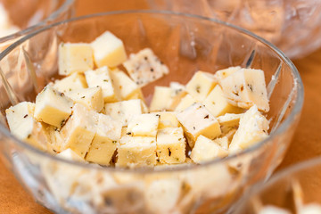 Cheese slices and pieces in a glass bowl
