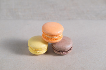three colorful macarons cake lying on a gray sheet of paper abstraction