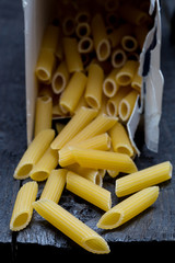 Penne Nudel auf dunklem rustikalen Holz