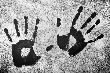 Hand prints on black background , sprinkled with white powder.