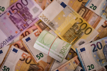 Obraz na płótnie Canvas rolled up one hundred euro notes bills on money background